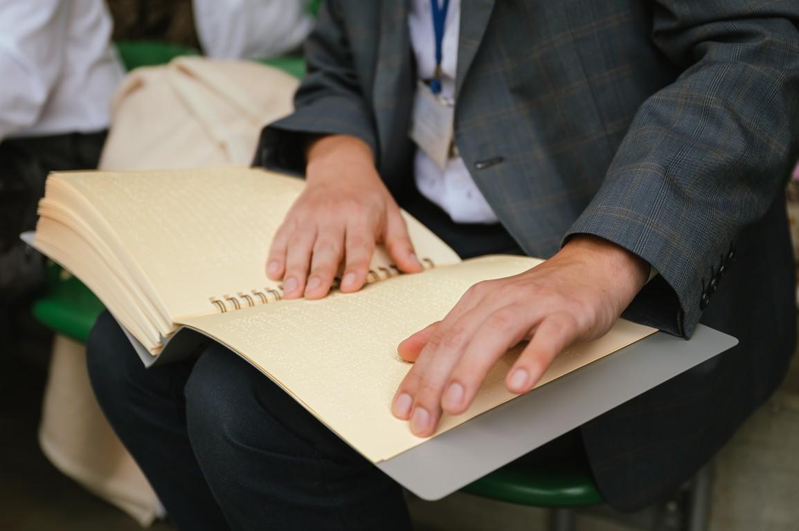 Niewidomy korzysta z Biblii w polskim brajlu