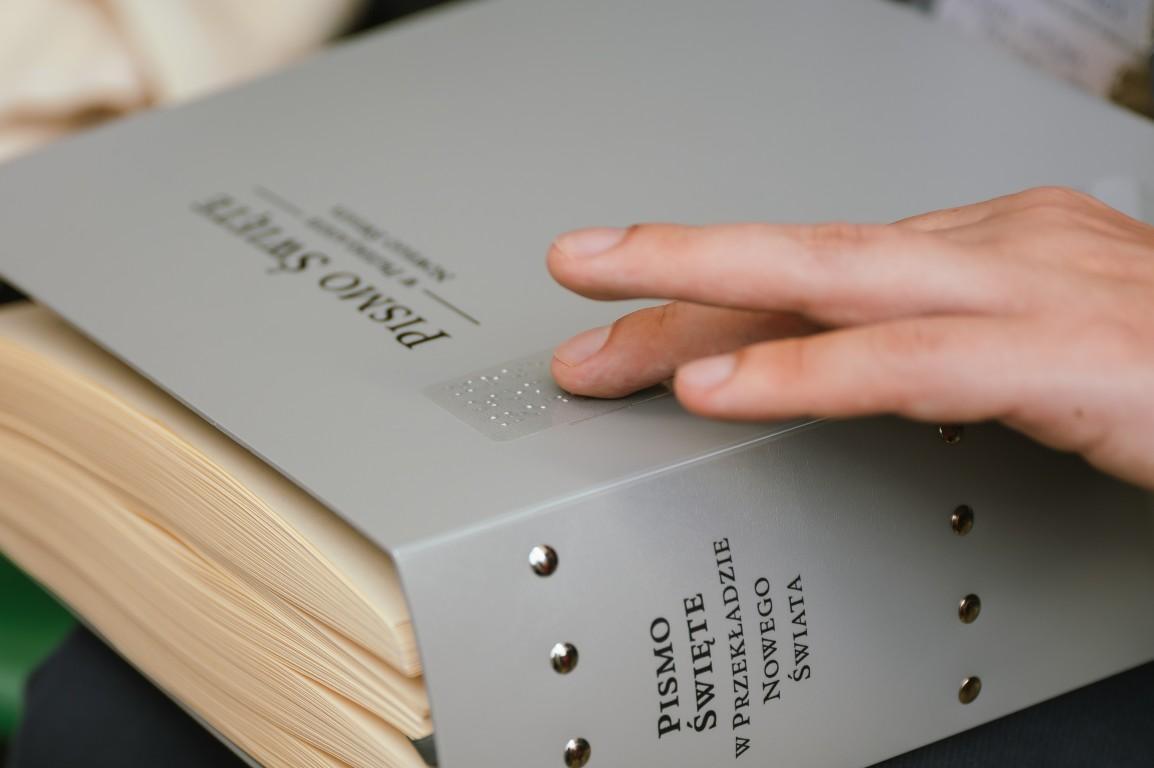 Niewidomy korzysta z Biblii w polskim brajlu