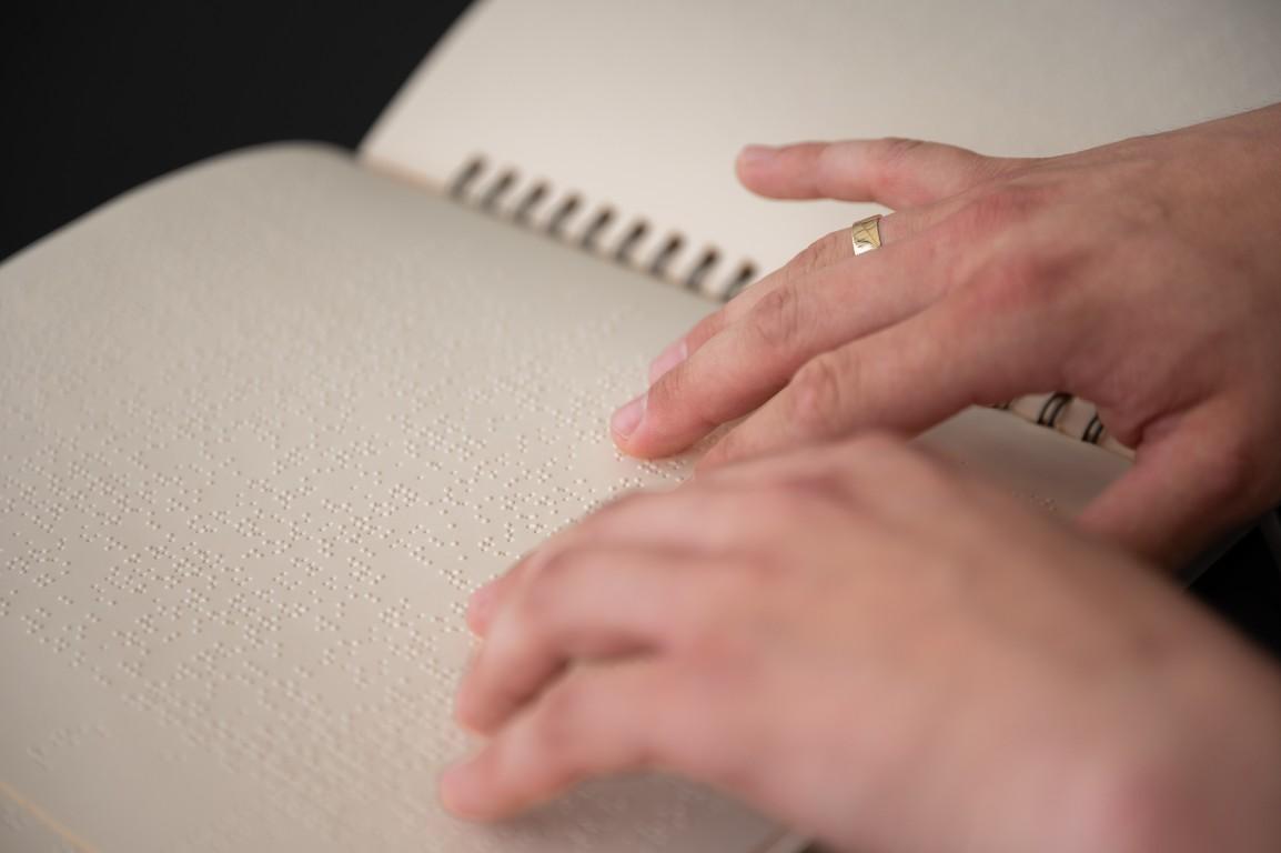 Niewidomy korzysta z Biblii w polskim brajlu