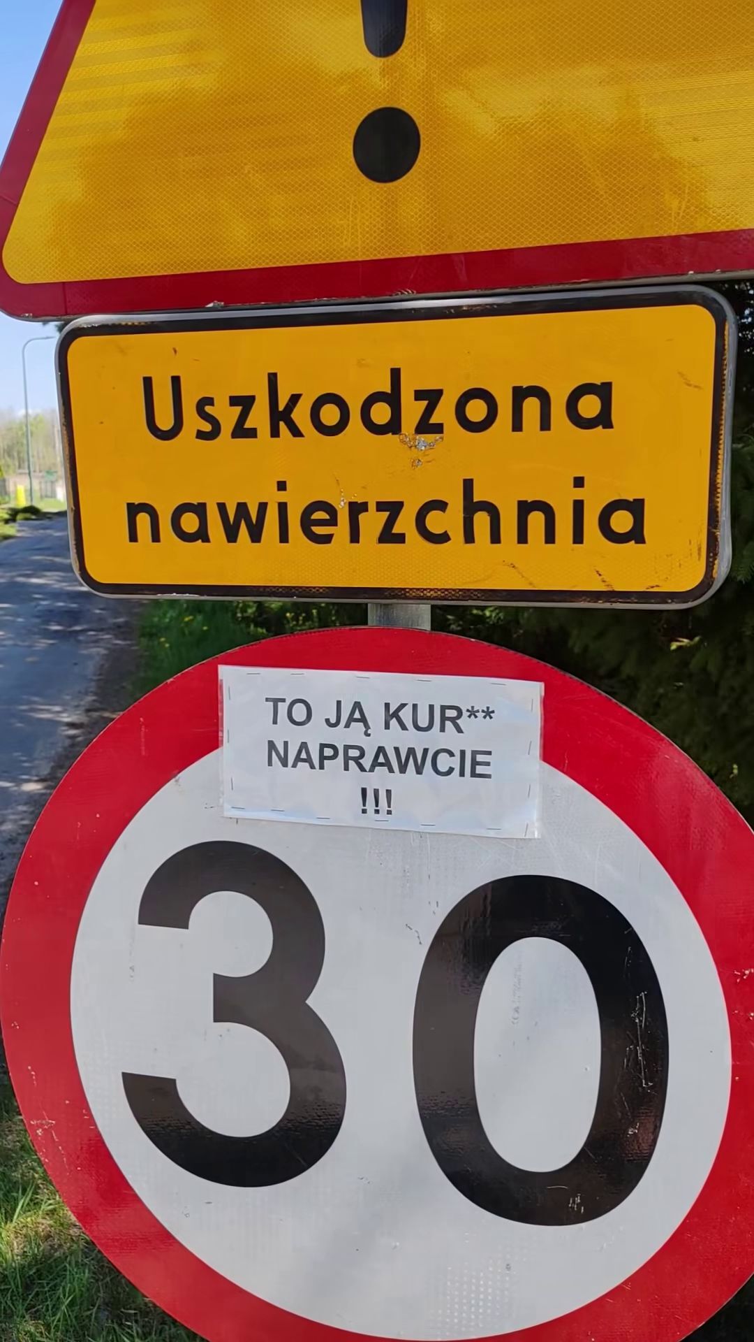 Dąbrowa Górnicza-Błędów. Znak ostrzegawczy przed dziurawą jezdnią. Z dopiskiem. 6 maja 2026