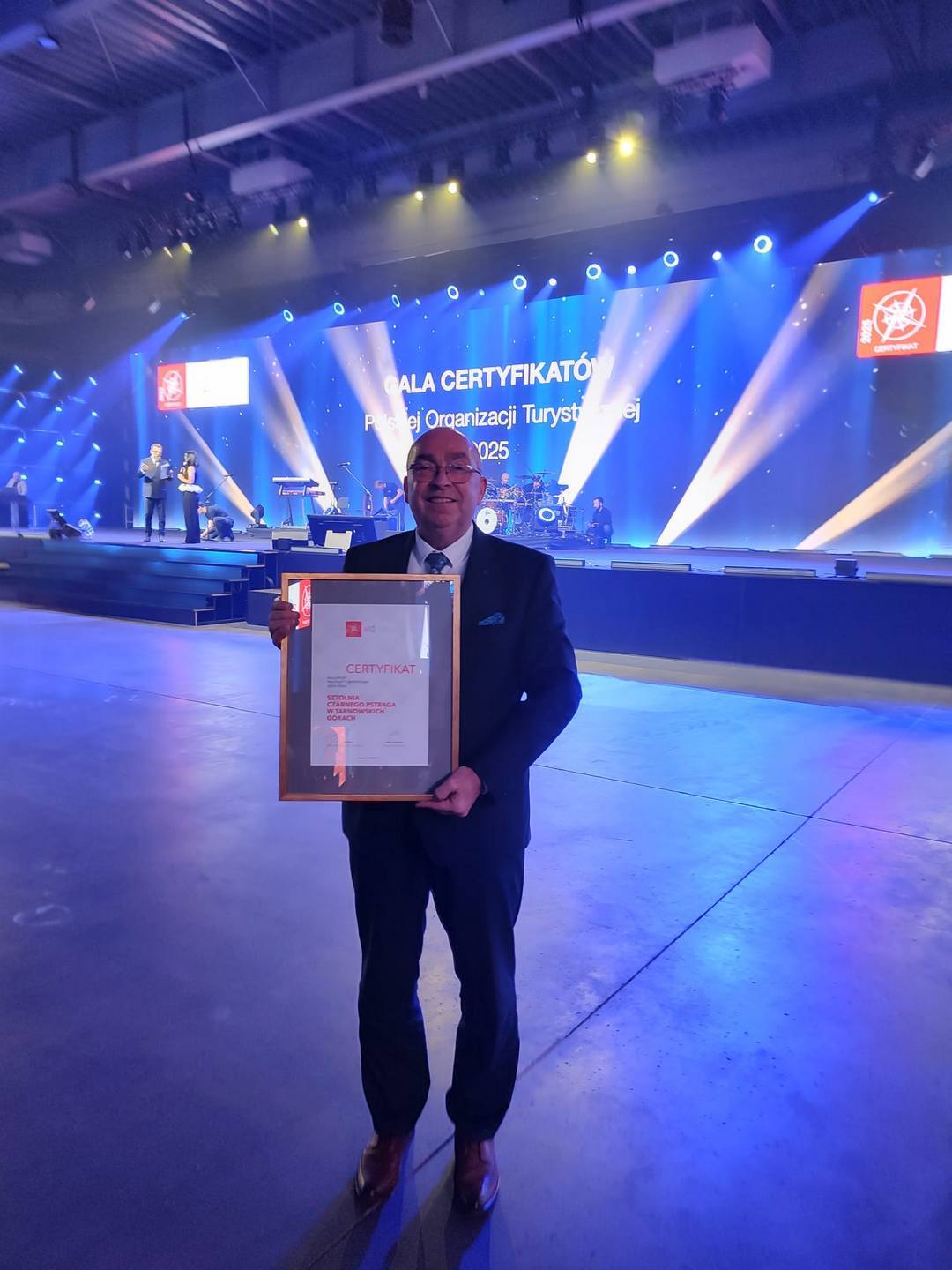 Poznań. Gala Polskiej Organizacji Turystycznej. Certyfikat – Najlepszy Produkt Turystyczny 2025 dla Sztolni Czarnego Pstrąga prezentuje Zbigniew Pawlak. 3 października 2025.