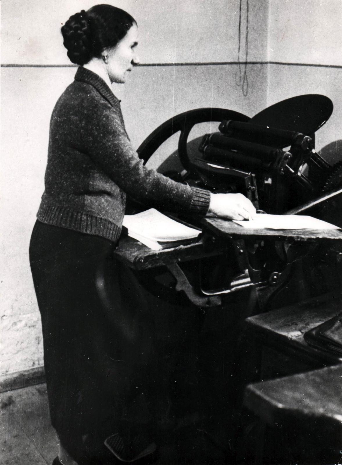 Drukarnia Jermułowicza w Sosnowcu. Przy maszynie drukarskiej, tzw. pedałówce – Maria Benisz Ciechońska. Początek XX wieku.