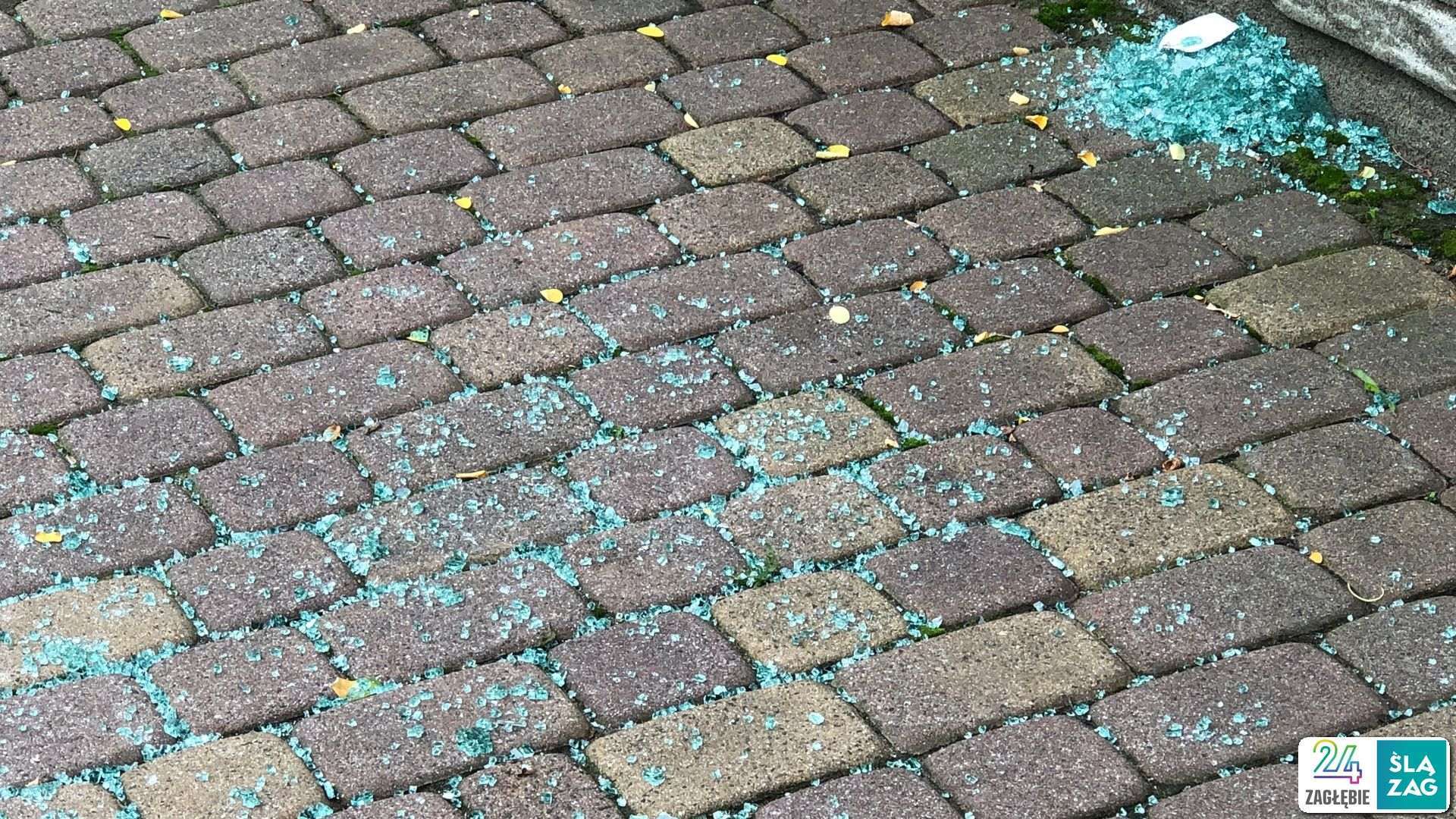 Sosnowiec. Ul. Franciszkańska. Sąsiedztwo skrzyżowania, gdzie Policja zastrzeliła mężczyznę atakującego pojazdy maczetą. Na chodniku resztki rozbitej szyby uszkodzonego pojazdu. 31 lipca 2025.